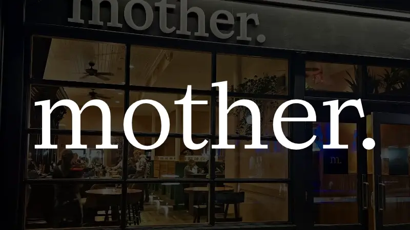 Logo with background image of restaurant frontage for "mother."